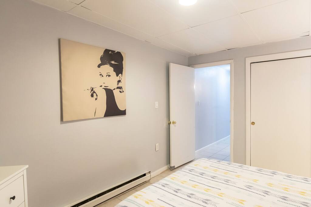 Bedroom with portrait and door going to the hallway