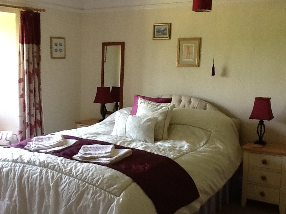 غرفة نوم في الطابق العلوي بسرير بحجم كينج يطل على الحديقة والكنيسة المجاورة