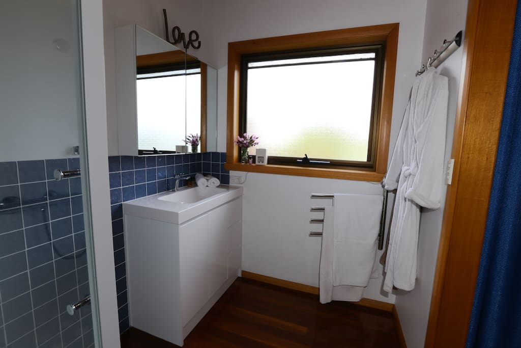 Modern bathroom with heated towel rails, bathrobes and toiletries.