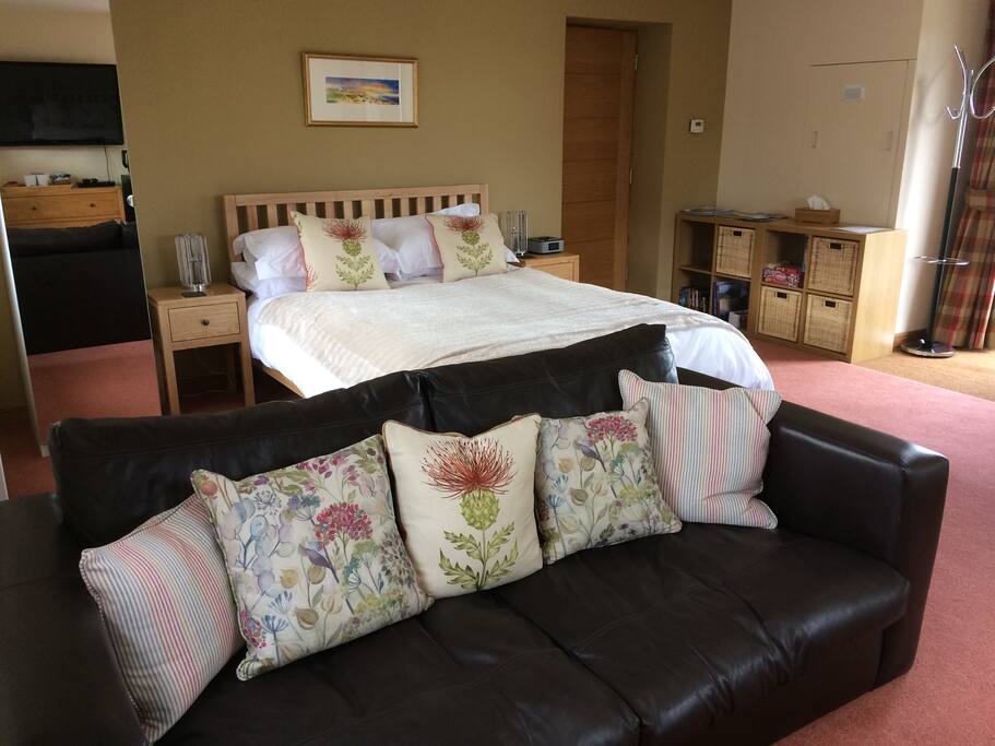 Room with wardrobe, sofa, king size bed. A nice room to relax in after a busy day sight seeing in the Highlands.