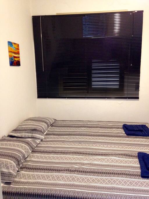 Quarto com duas camas box e janela lateral.