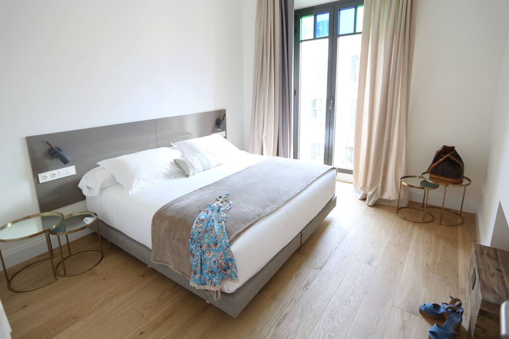 Habitación doble con armarios empotrados, vistas a la plaza, cama de matrimonio de hotel y cortinas de hotel donde tapan la luz.