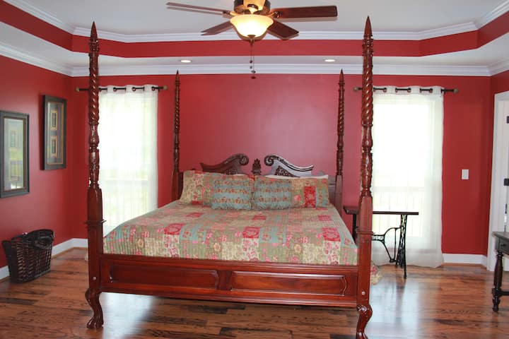 Hauptebene - Master Suite mit Blick auf den Pool, Balkonzugang und Kingsize-Bett, Fernseher, Whirlpool-Badewanne, begehbare Dusche, Doppelwaschbecken, begehbaren Kleiderschrank, Kommode und Schminkwaschbecken.