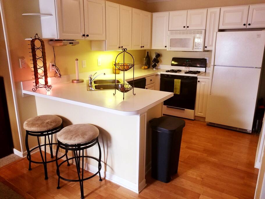 Full kitchen with island bar seating for two. Dishwasher, gas stove, microwave, toaster oven, and food pantry to right of the picture.