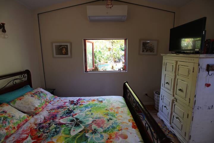 cabaña cama tamaño queen y vista a la piscina de la laguna
