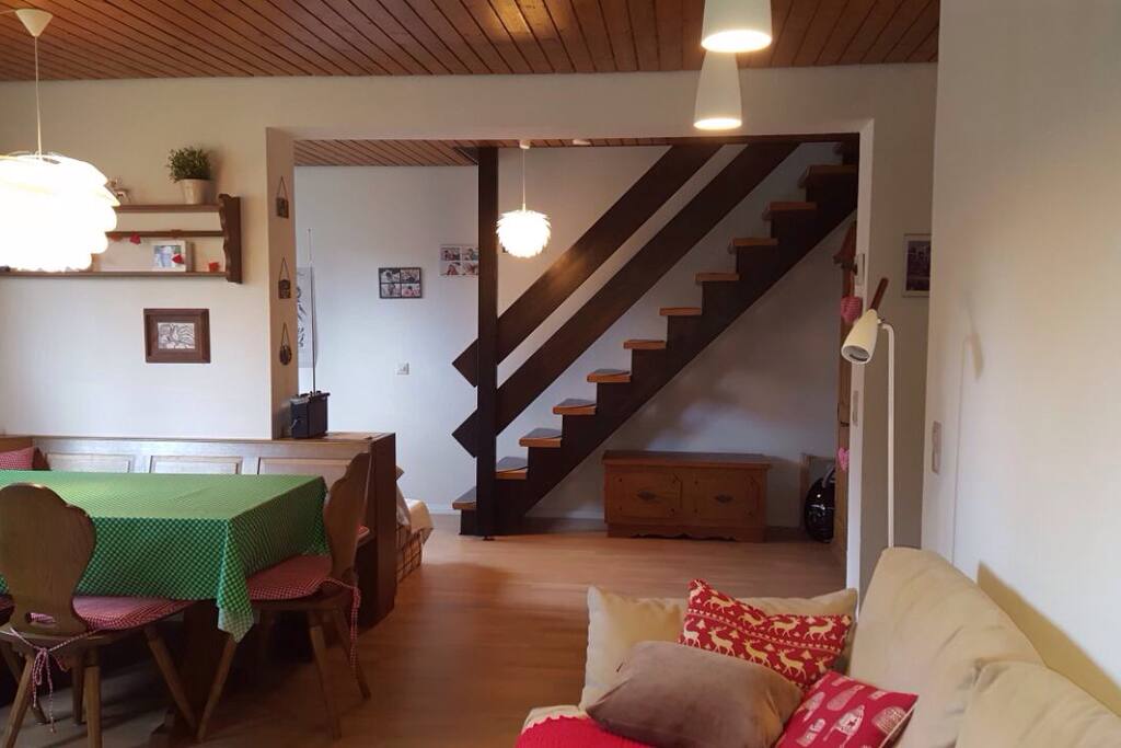 Wohnzimmer mit Esstisch und Blick auf Treppe zum Obergeschoss
