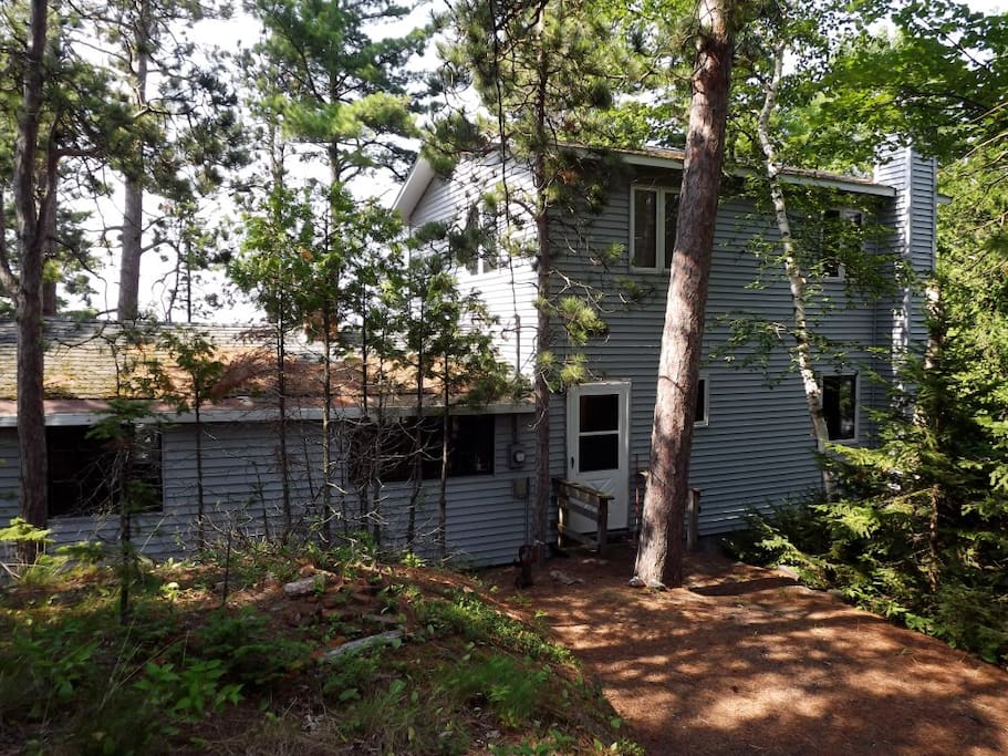 House is tucked in the woods but immediately adjacent to the road.