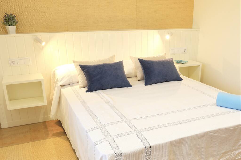 Una amplia cama de matrimonio en un luminoso dormitorio.
