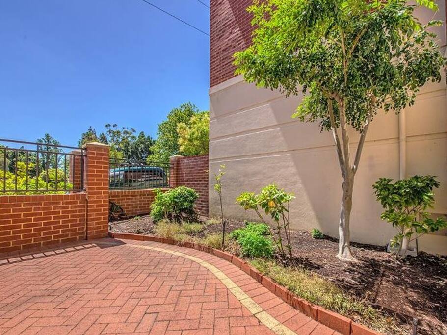 Private courtyard has out door sitting under the leafy tree