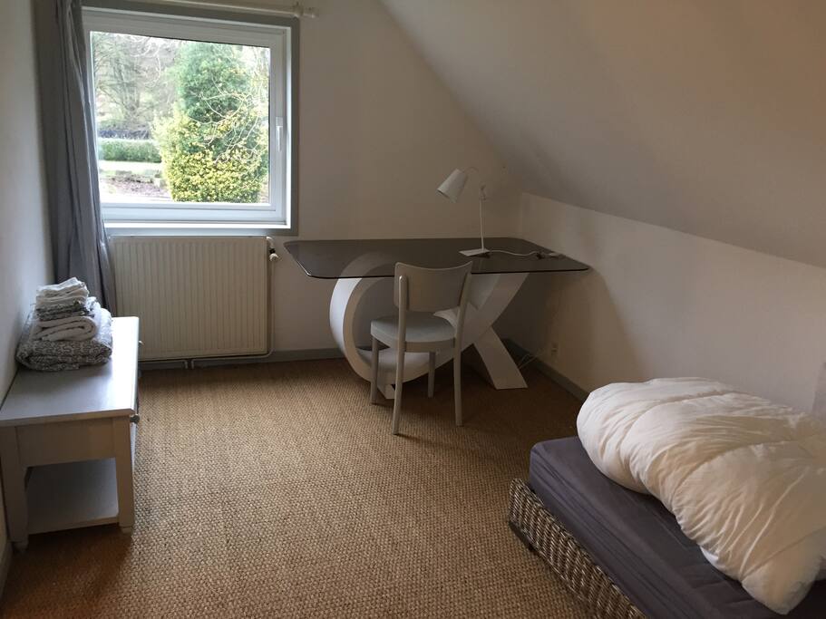 Chambre blanche. Bureau et vue verdure