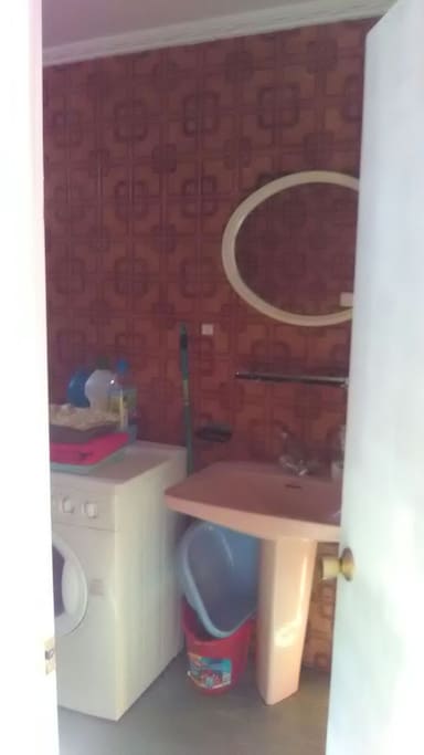 Cuarto de baño con bañera, lavadora y retrete. Ilumniación led