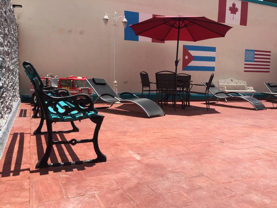 Huge private terrace for the guest with bar, deck chairs, tables, chairs and umbrellas.