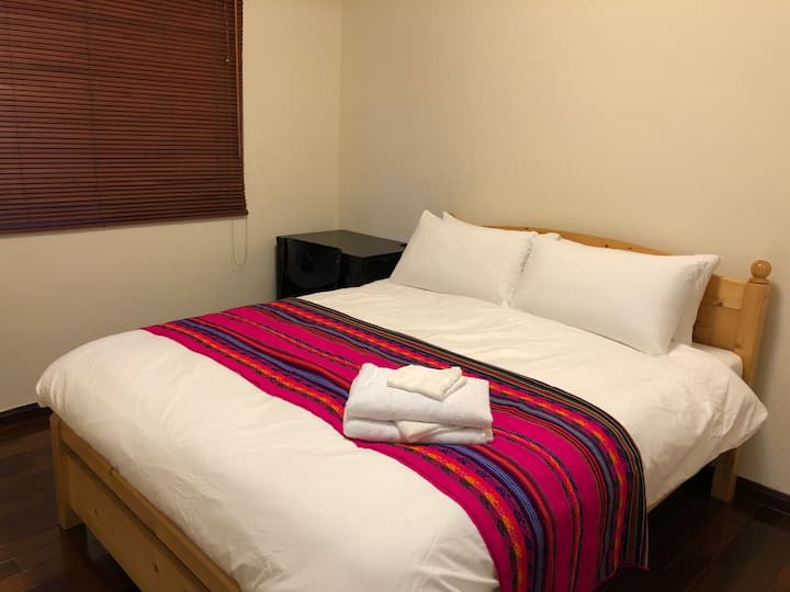 Rum 2 Queen-säng med garderob, byrå och skrivbord.
雙人房2 