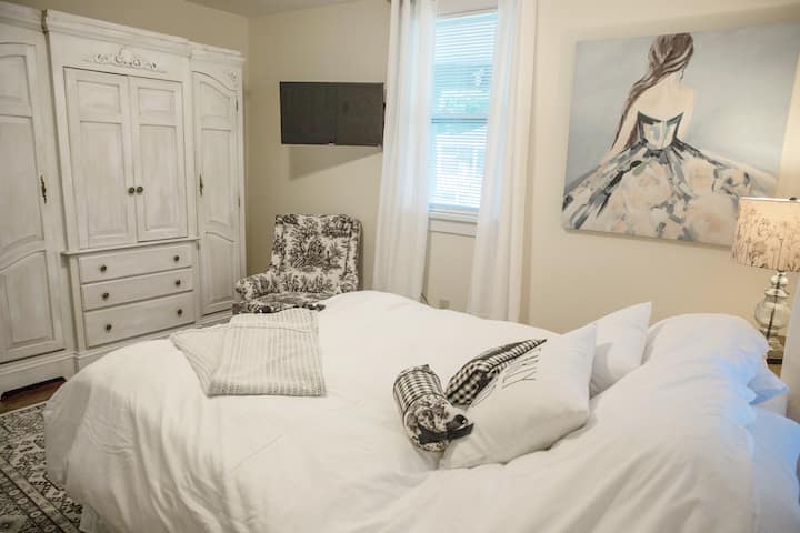 Boudoir de temática francesa con una lujosa cama tamaño queen y edredón de plumón