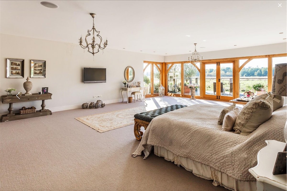 Dhoma kryesore e gjumit me përmasa shumë të mëdha 7.5 metra hapësirë xhami dhe dyer në verandë dhe lumë privat