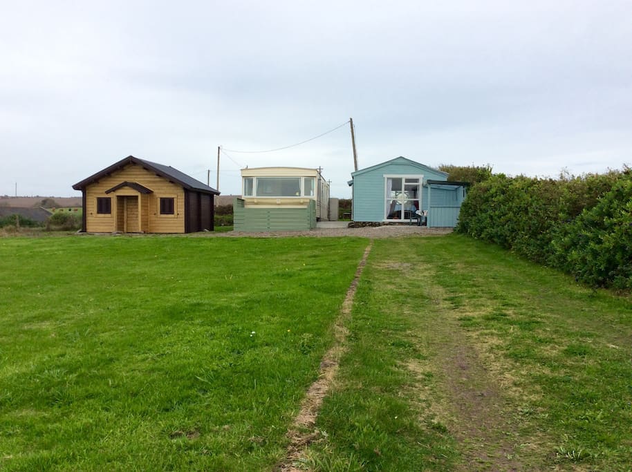The site showing the blue bach, the mobile home and the brown cabin