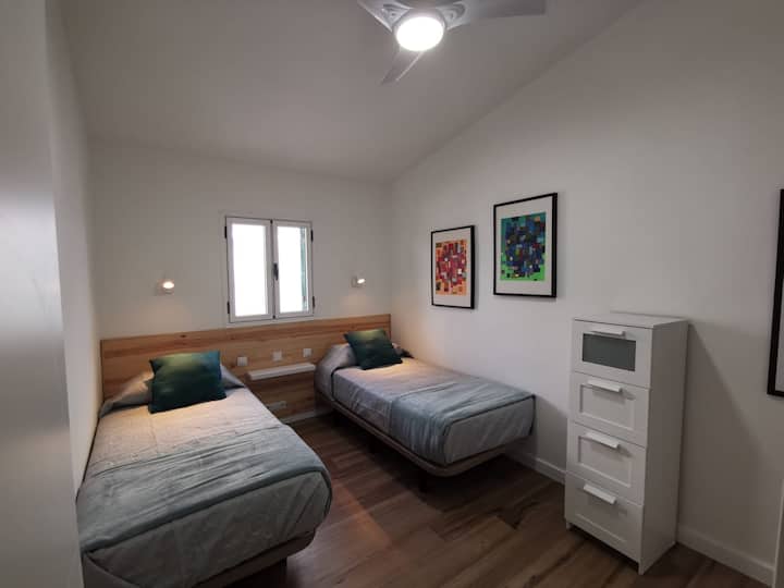 Soba s udobnim krevetima. Prozor koji vodi do privatnog vrta i mreže za komarce.