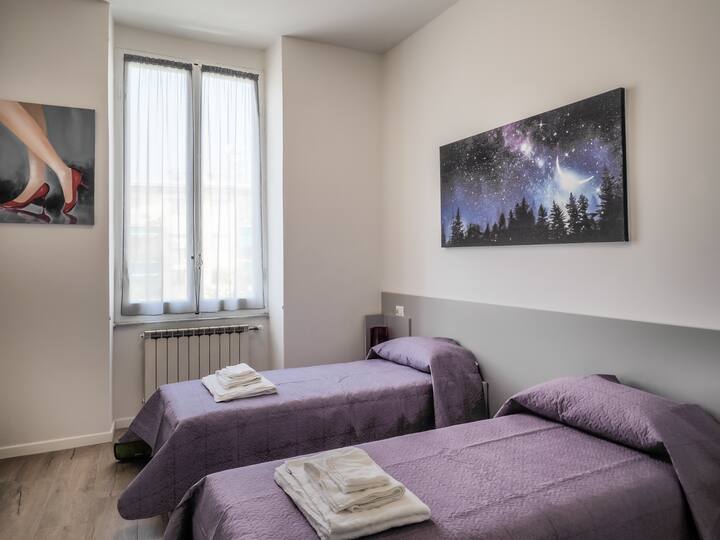 חדר שינה עם שתי מיטות יחיד, ארון גדול וטלוויזיה