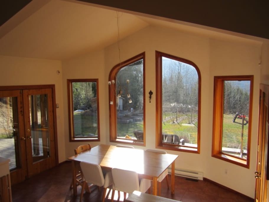 View from dining room out to gardens full of home-grown food for you to eat ! French doors with screens open onto patio.