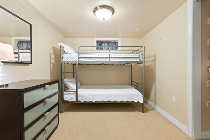 غرفة في الطابق السفلي بسرير بطابقين لاستيعاب أطفالك أو البالغين الحنين إلى الماضي.