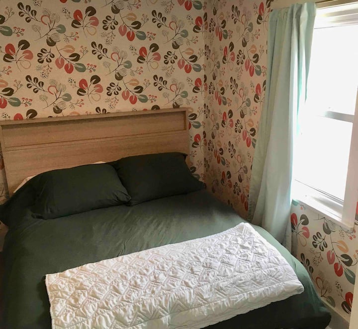 Chambre #1 avec lit double/complet. La chambre donne sur les voiliers dans le hangar à bateaux de l'autre côté de la rue.