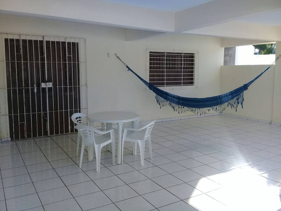 Terraço garagem (5,50 x 7,00m) equipado com mesa plástica com 04 cadeiras e rede para casal.