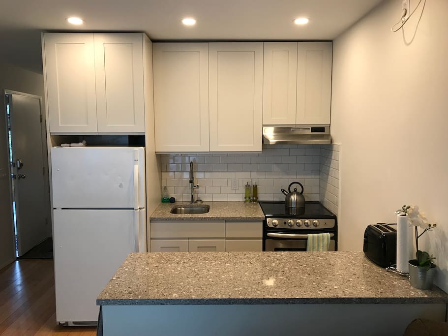 Modern and convenient - full sized fridge and cooktop with stone benchtops. Our kitchen is set up for chefs. Coffee, tea, salt, pepper are provided so you can self-cater your entire stay.