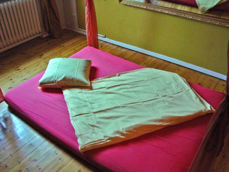 Futonbett, 140 x 200 cm unter einem Betthimmel, heimelig und wohlig.
