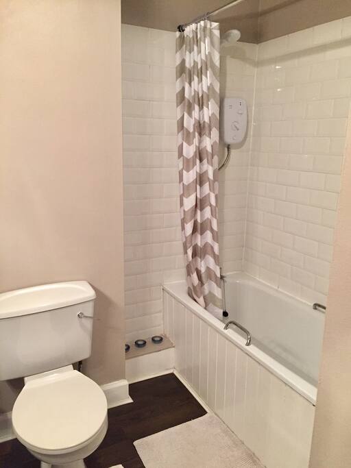 Bathroom with electric shower and enamel bath