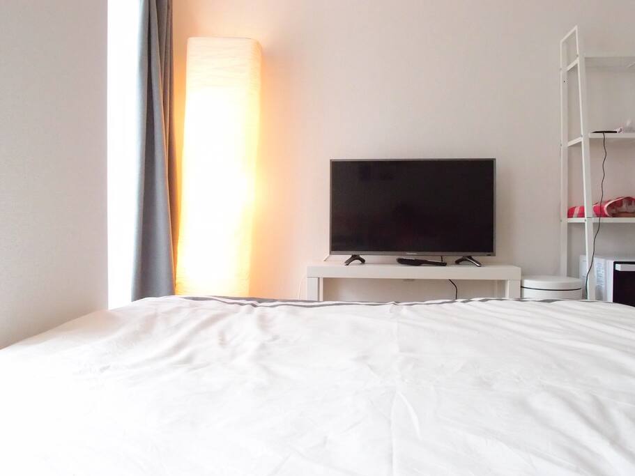 a 32inch TV is in front of a bed