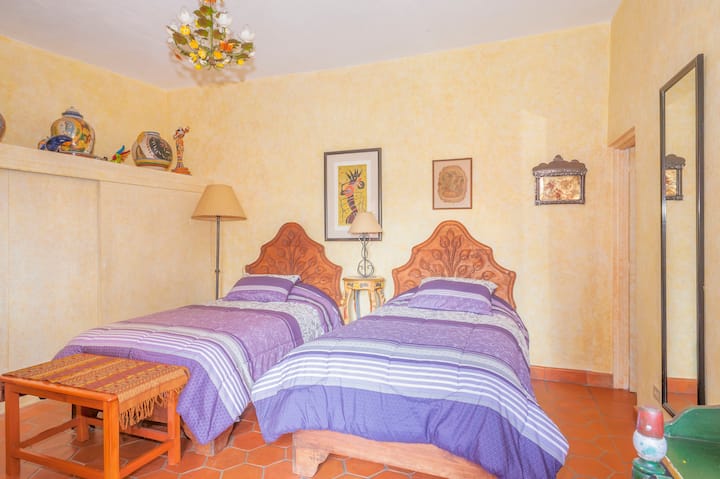 Suite amarilla con dos camas y armario de pared a pared