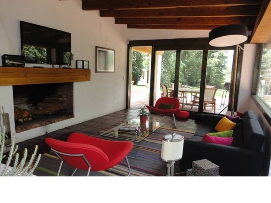 Mobilario, cojines y tapetes de diseño. Litogafías y grabados en seda de pintores reconocidos. Ventanas y puertas verde bosque en armonía con el resto de la casa. Puertas corredizas. Integran magnífica terraza y jardín N°2 con la sala.