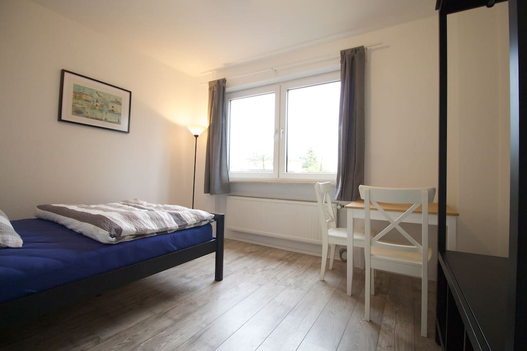Zimmer mit Doppelbett, Tisch und Stühlen und Kleiderschrank