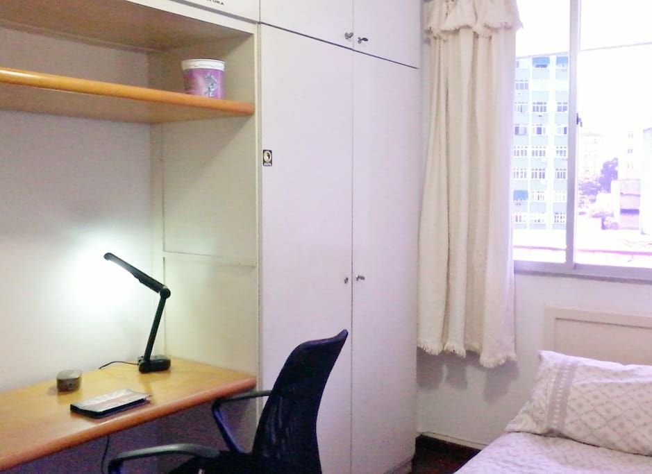 The desk, an armchair and a lamp.
Há uma, lâmpada, escrivaninha, cadeira de escritório.