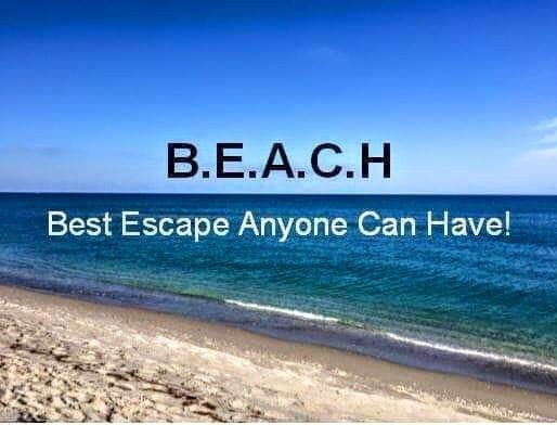 A serene beach scene features a calm ocean with gentle waves lapping at the shore. The sky displays a gradient of blue hues, transitioning from light at the horizon to deeper shades above. Sandy shoreline extends across the foreground, enhancing the tranquil atmosphere.