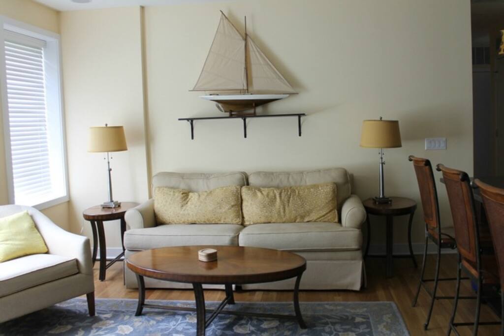 Spacious sunny living room area with queen size pullout couch and surround sound.