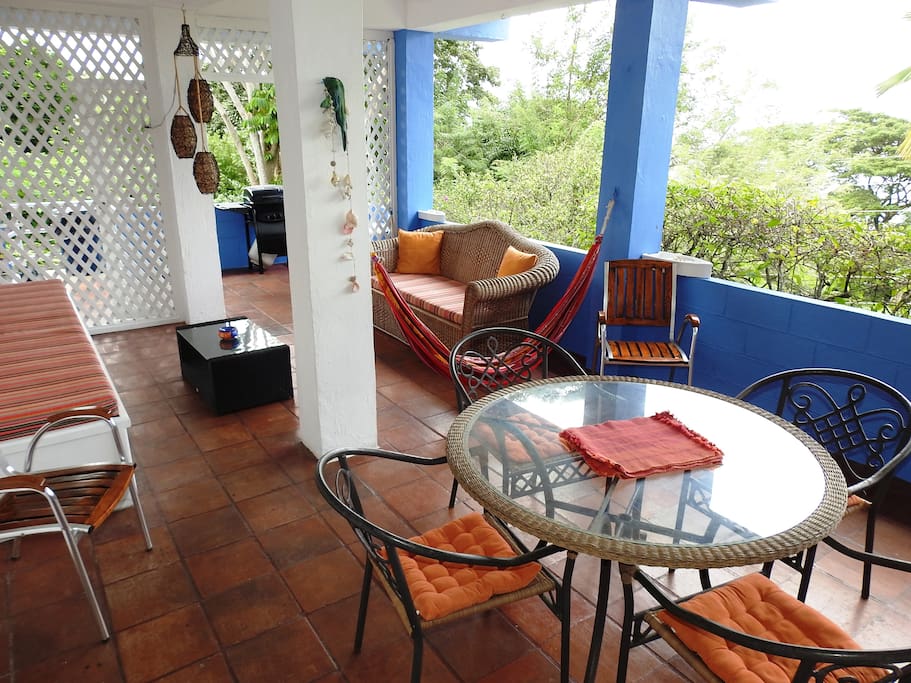The apartment has a large balcony overlooking the pool and lush garden