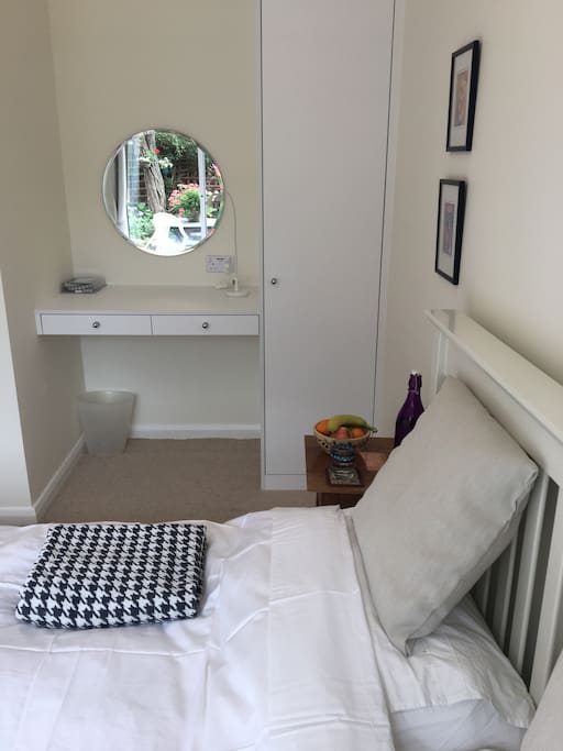 Wardrobe and desk area next to comfortable double bed and with smart TV