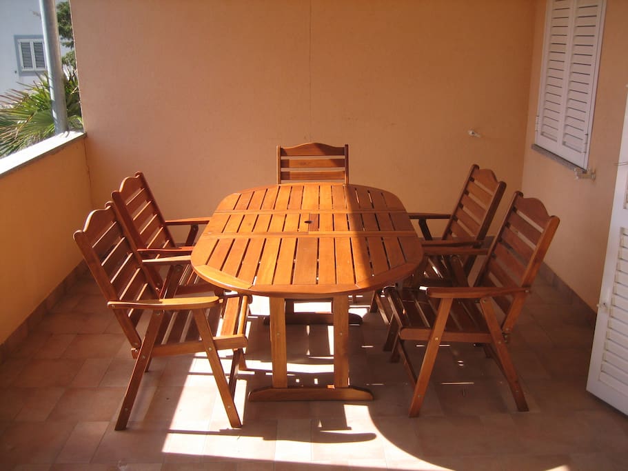 Large balcony with table and chairs.