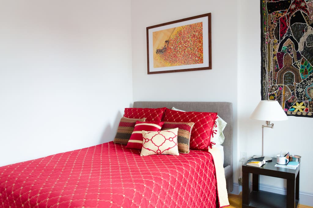 Comfortable double bed with headboard, and tapestry from India