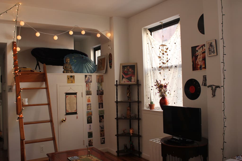 Separate loft that fits blow up bed, stocked with books for relaxation.