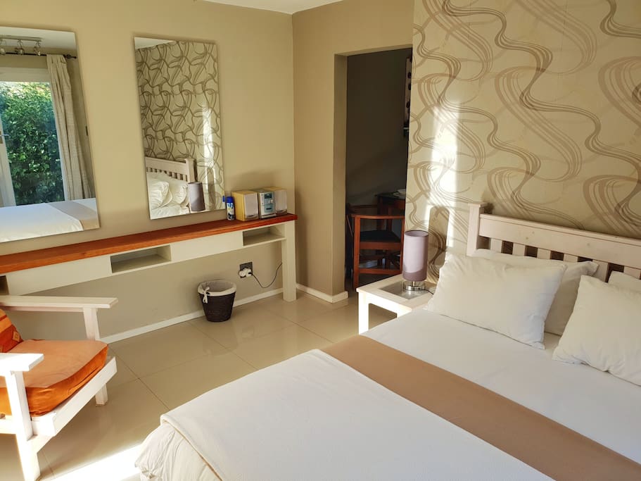 Mirrors, Sound System, Double Bed and Lounge chair in Bedroom