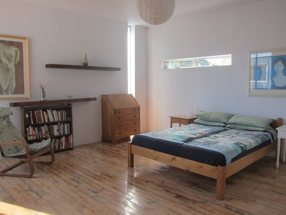 Master Bedroom, queen bed with books, en-suite and balcony.