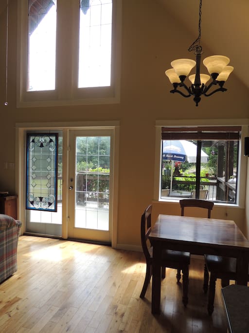 Bright dining area seating 4 people with an additional table and chairs on the deck.