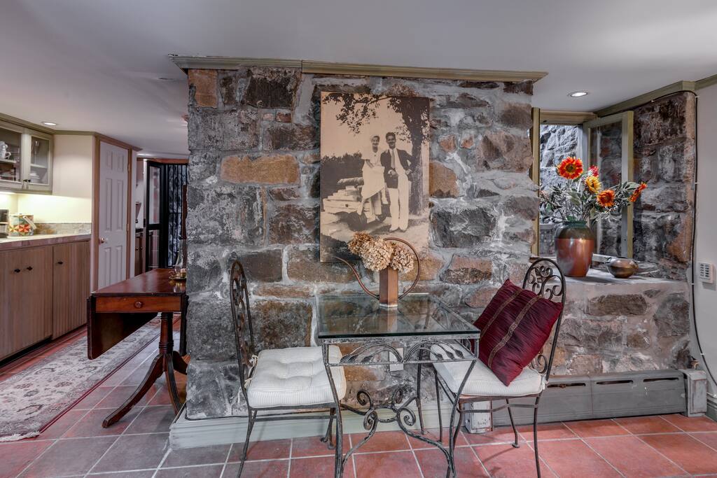 Enjoy a lovely breakfast at glass top table against stone wall.