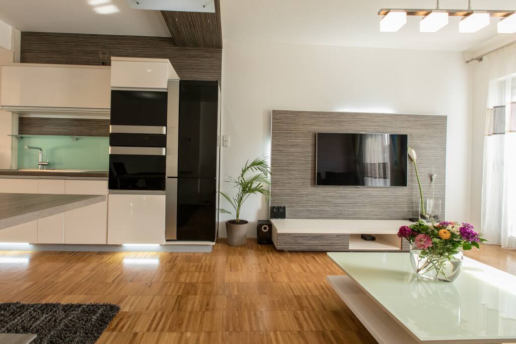 Kitchen and Living room area with flat screen, Apple TV, Wireless Speakers & International channel selection.