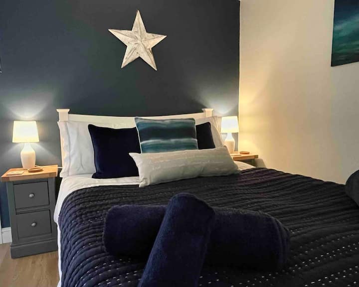 Beautifully styled with coordinated touches, the bedroom offers a peaceful and inviting retreat after a day of exploring. For your comfort, an oscillating fan is provided to keep you cool on warm summer evenings, while soft lighting enhances the mood