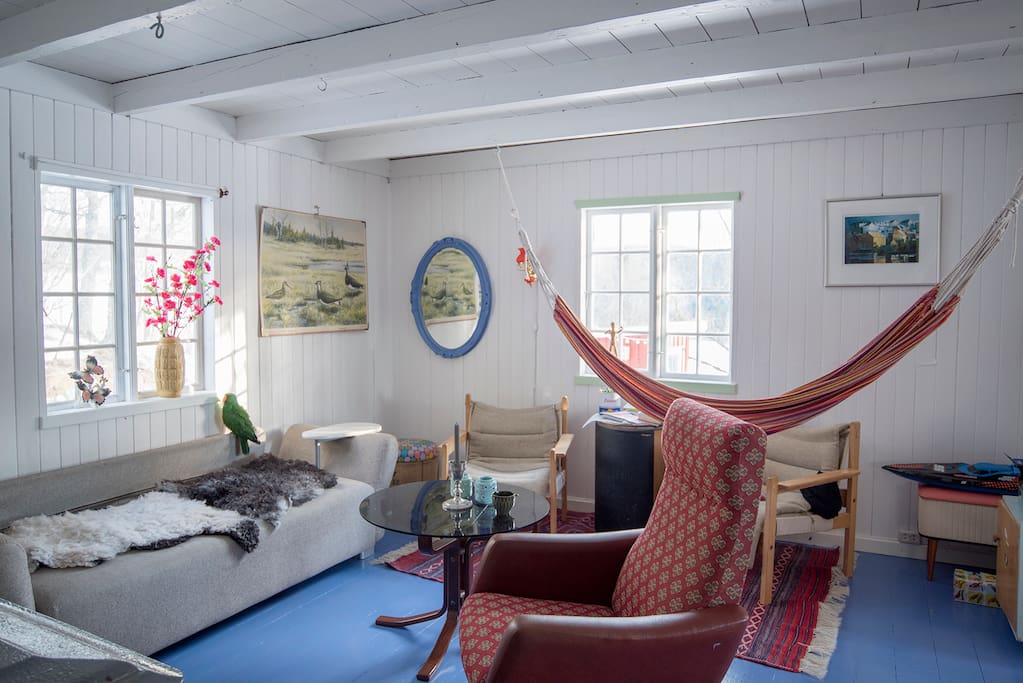 Stua er koselig innredet med retro møbler og hengekøyer i taket.