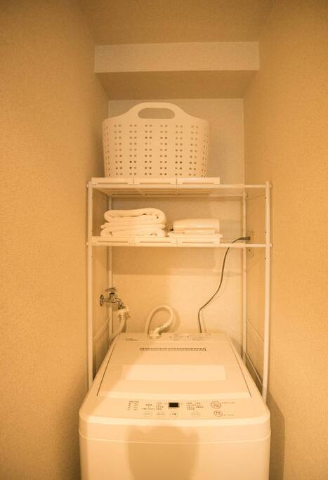 A washing machen, detergent for clothes, towels and some hangers.