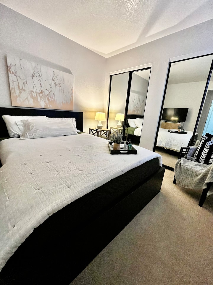 Segundo dormitorio con cama tamaño queen, televisión y espacio en el armario 